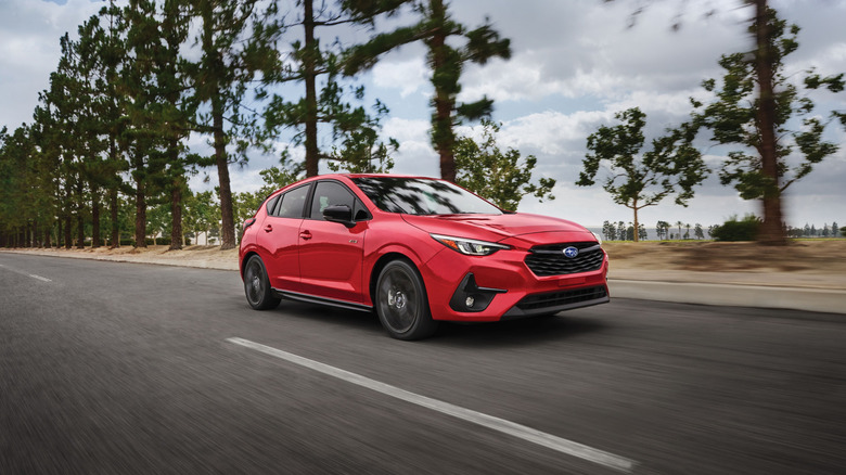 A red 2025 Subaru Impreza on a roadway.