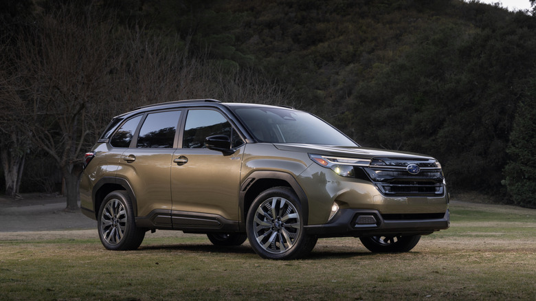 A gold 2025 Subaru Forester Hybrid parked on grass.