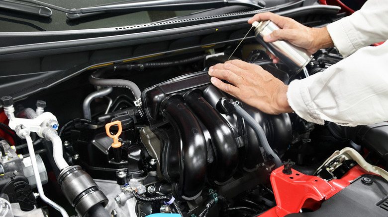 Man cleaning the engine bay using a degreaser