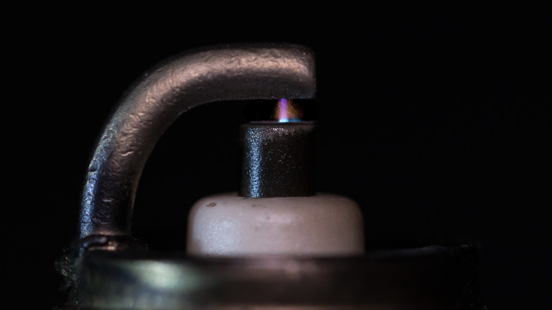 A closeup of an a spark plug firing