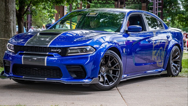 A Dodge Charger SRT Hellcat on display in a park-like setting.