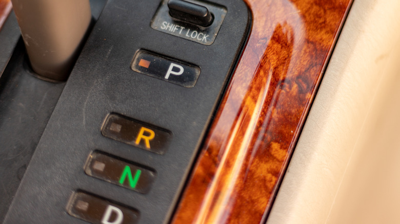 An up close shot of an automatic transmission's selections: park, reverse, neutral, and drive.