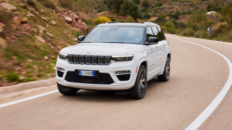 A white 2026 Jeep Grand Cherokee driving on a curvy road