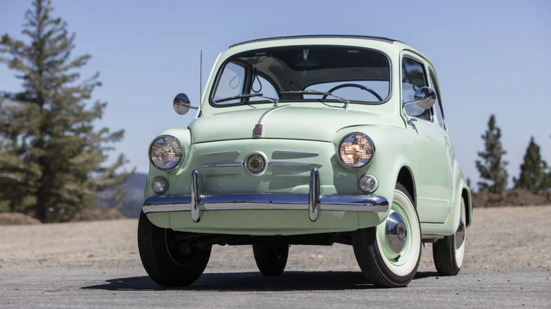 A fiat 600 in mint green parked on a mountain top somewhere in California