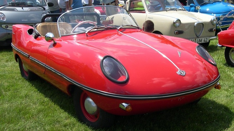 A red Goggomobil Dart parked among other micro cars at a car show