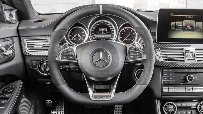 The interior of a 2014 Mercedes-Benz CLS 63 AMG with its analog-digital instrument clusters front and center. And so many buttons.