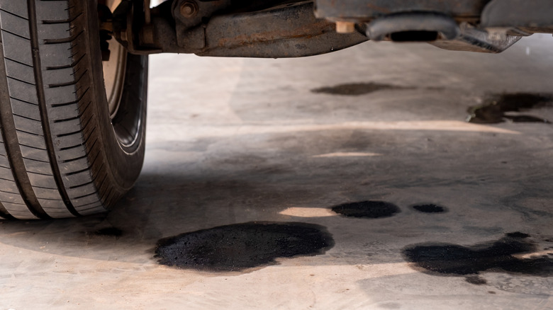 Several visible oil stains on the pavement under a car
