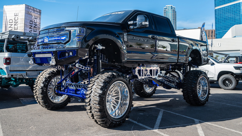 A heavily modified and lifted pickup truck at the SEMA show parking lot in Las Vegas