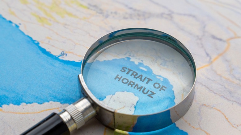 A magnifying glass on map showing the Straight of Hormuz