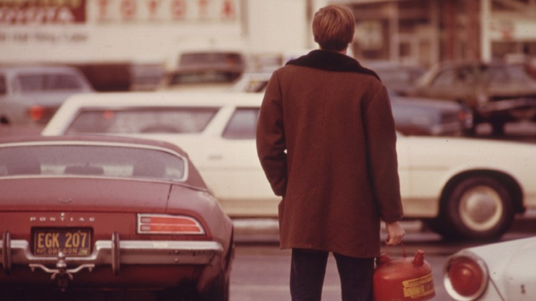 A man standing in line with a gas can during the oil crisis