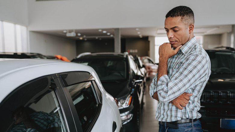 A person looking at a car in a dealership