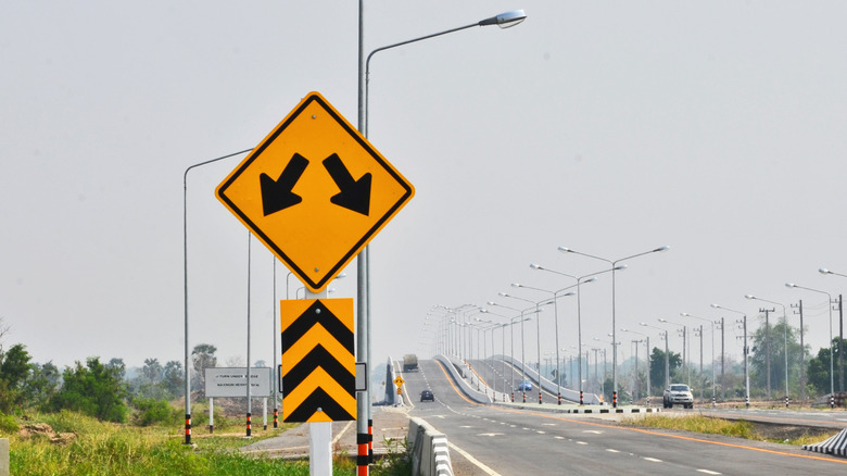 A divided highway sign next to a split four-late highway