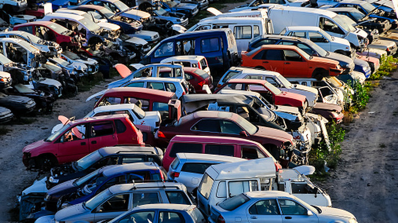 A scrapyard with piles of crushed cars