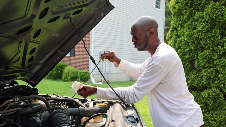 Man checking the oil in his car.