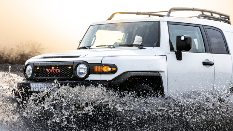 White FJ Cruiser off-road in a mud puddle