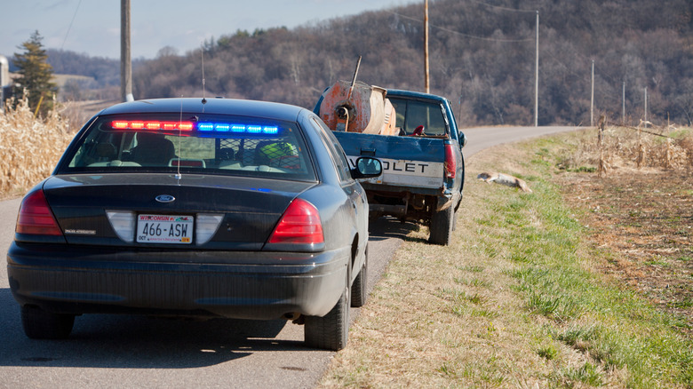 An unmarked police cruiser on a rural road in Wisconsin with interior red and blue lights.