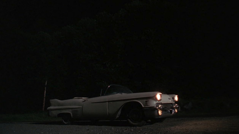 Screenshot of the Peacock family's 1958 Cadillac Series 62 on a dark driveway with the lights on from The X-Files Season 4 Episode 2 "Home."