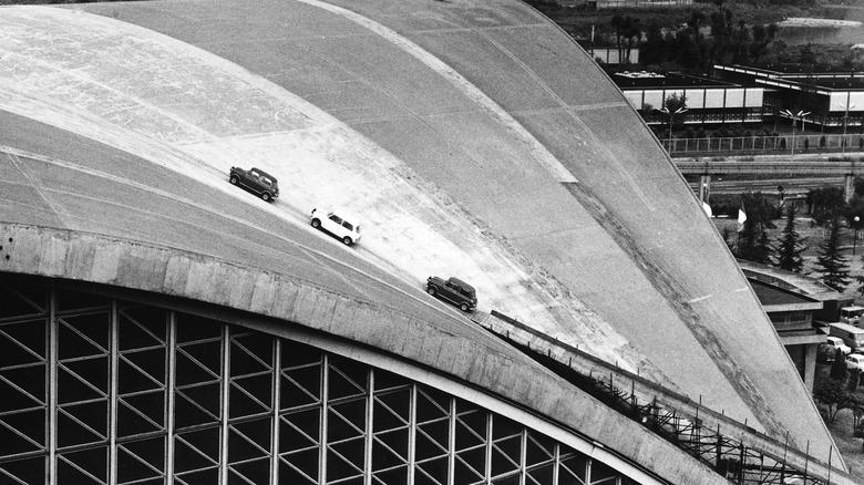 Three minis driving on the roof of a concrete building, in black and white. A still from the original film, The Italian Job.