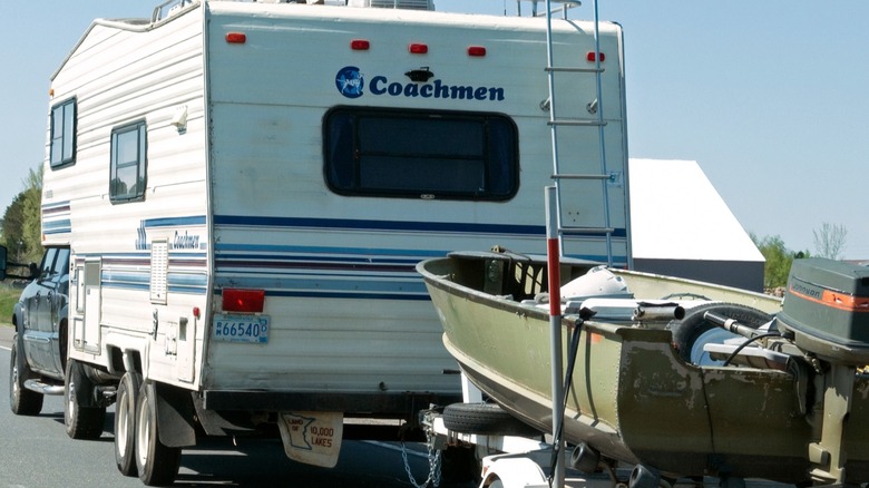 A pickup tows a camper and a boat, double towing