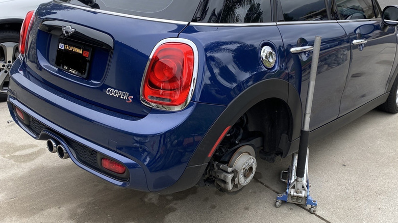 A photo of the rear of my blue Mini Cooper S while its on a jack with the rear tires removed