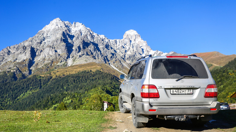 Mazeri, Georgia - September 23, 2025: Japanese luxury offroad car Toyota Land Cruiser 100 at the background of the Ushba mountain.