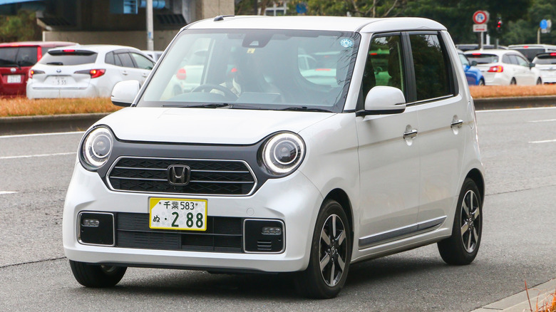 A white Honda N-ONE sitting at a traffic light in Japan.