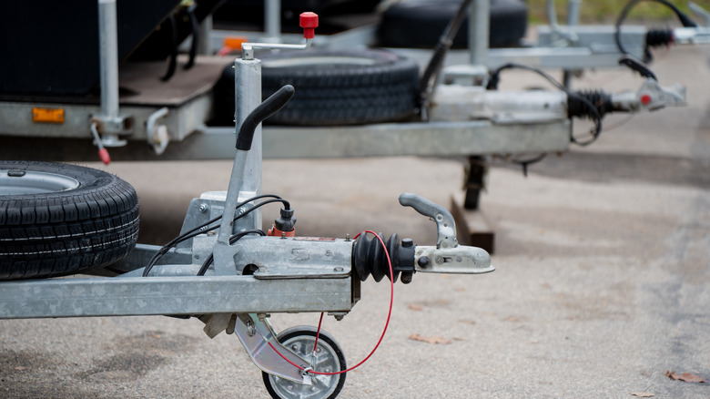 Metal trailer hitch with hand brake lever and a wheel