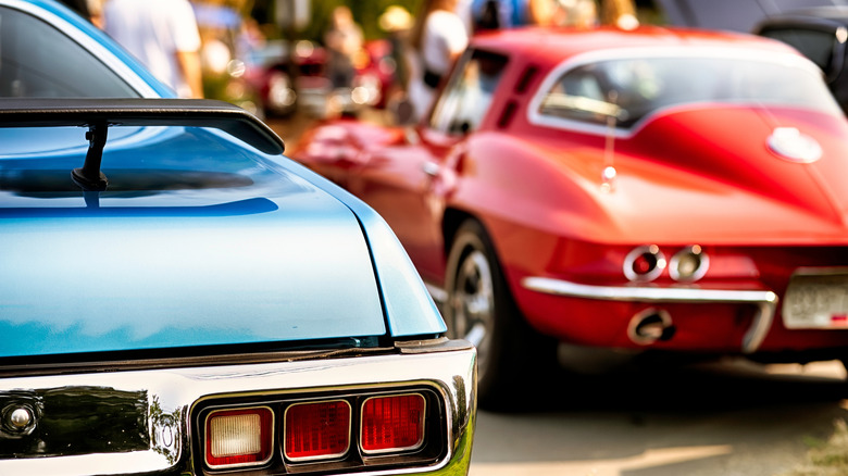 Red and blue classic muscle cars parked at a show