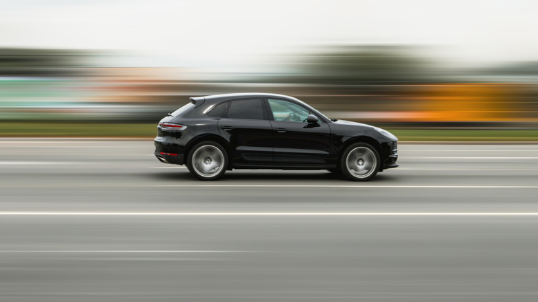 ماشین سیاهی که در جاده در حال رانندگی است