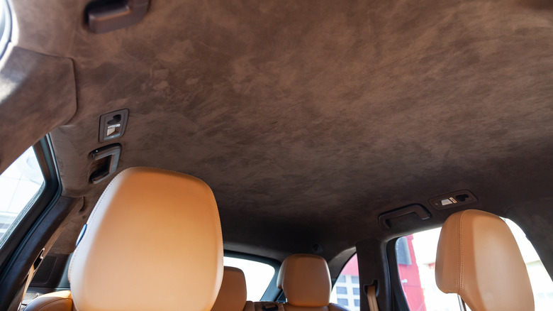 A view of a luxury car's brown suede headliner.