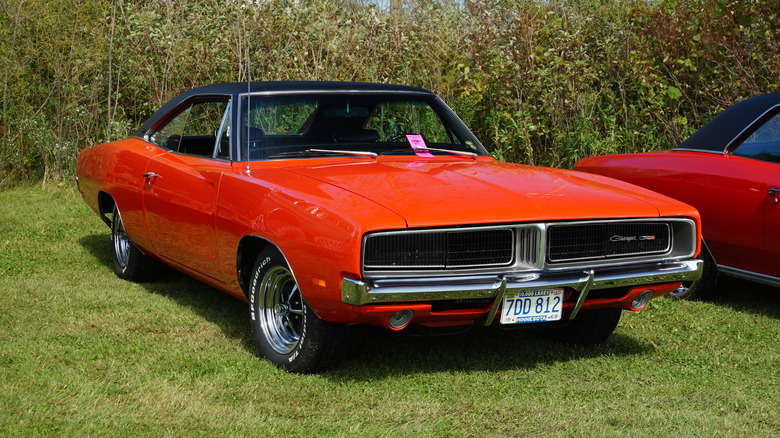 An orange 1969 Dodge Charger on a grass lawn