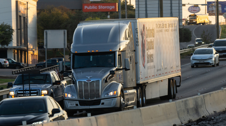 A semi truck driving on an interstate highway.