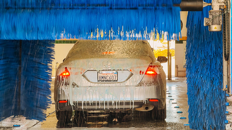 A car moves through a brush-equipped automatic car wash.