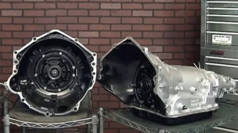 Two 4L60E transmissions with one being viewed from the side.