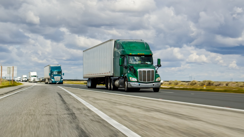 A line of semi trucks on the highway