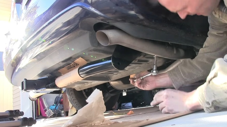 An aftermarket tow hitch system being installed on a vehicle