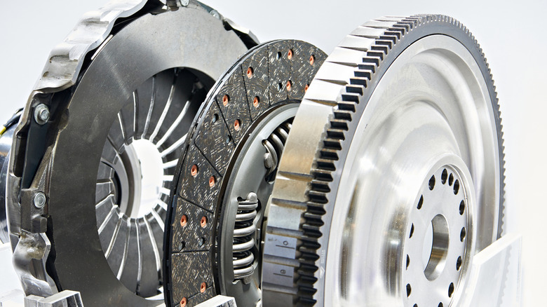 From left: a clutch pressure plate with diaphragm springs, a clutch disc, and a flywheel.