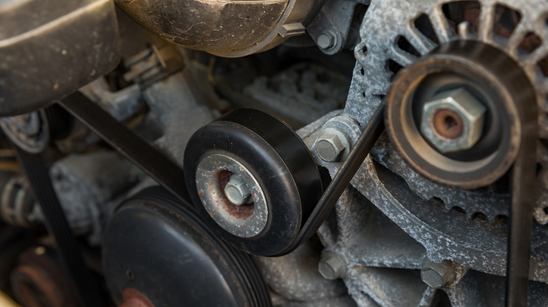 The front side of an engine showing its accessory belt drive and a handful of pulleys.