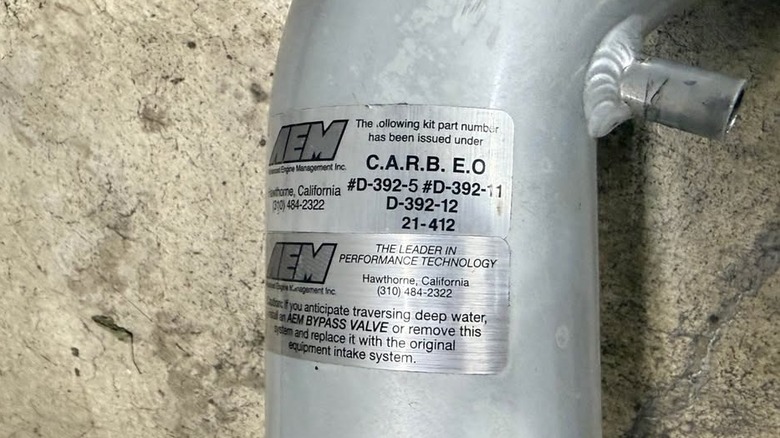 An AEM air intake with a C.A.R.B. sticker