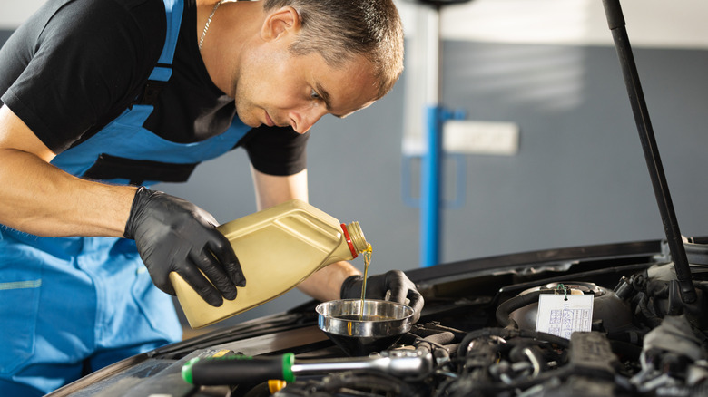 Mechanic adding lipid to engine
