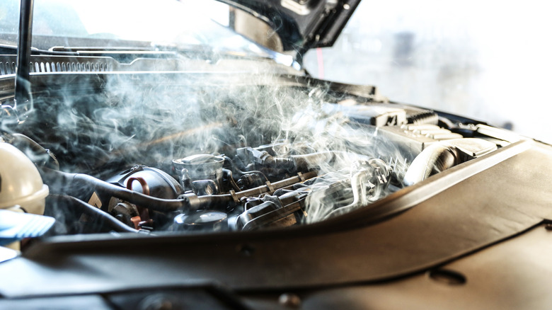 A damaged car motor showing smoke
