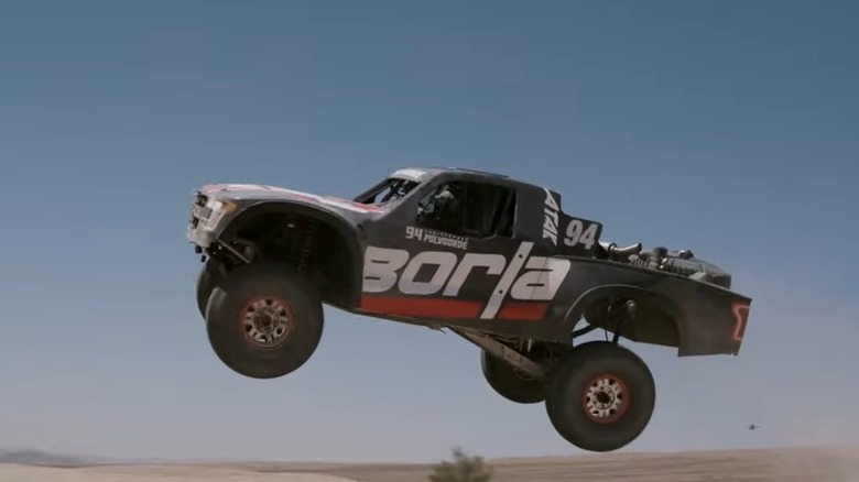 A luxury PreRunner flying through the air using a Ford Megazilla for off-road competition