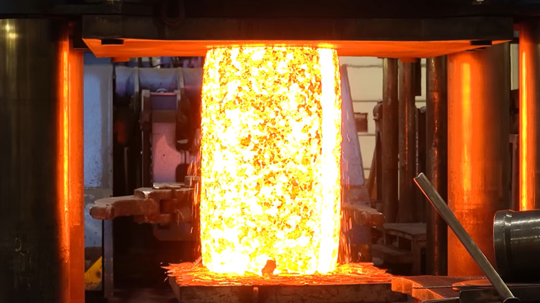 Hot metal being forged using compression and heat