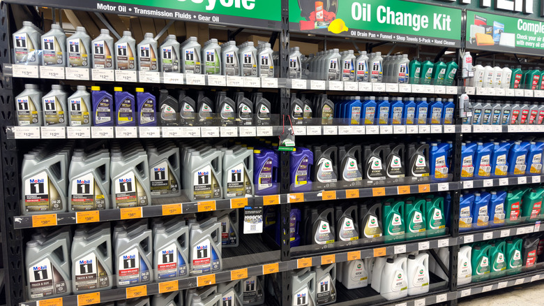 Motor oil bottles fill up multiple shelves in an auto parts store.