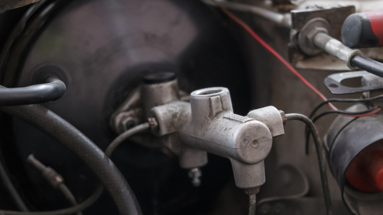 Close-up of a vacuum brake booster under the hood of a car.