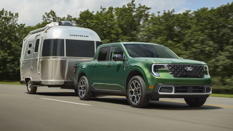 A green Ford Maverick towing an Airstream camper.