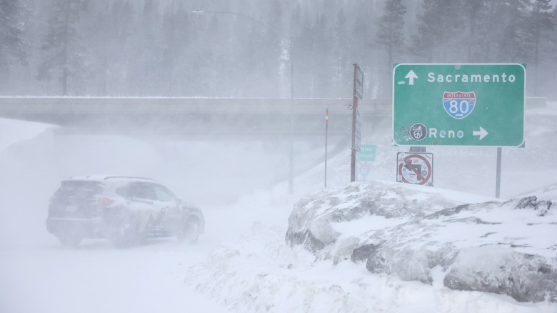 KINGVALE, CALIFORNIA - FEBRUARY 29: A vehicle drives through blowing snow near Interstate 80 (I-80) in the Sierra Nevada mountains at the start of a powerful winter storm on February 29, 2024 near Kingvale, California. Blizzard warnings have been issued with snowfall of up to 12 feet and wind gusts of up to 100 mph expected in some higher elevation locations during the multiple day storm.