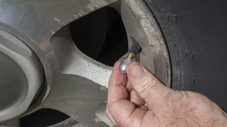 A mechanic installing a new valve stem into tire