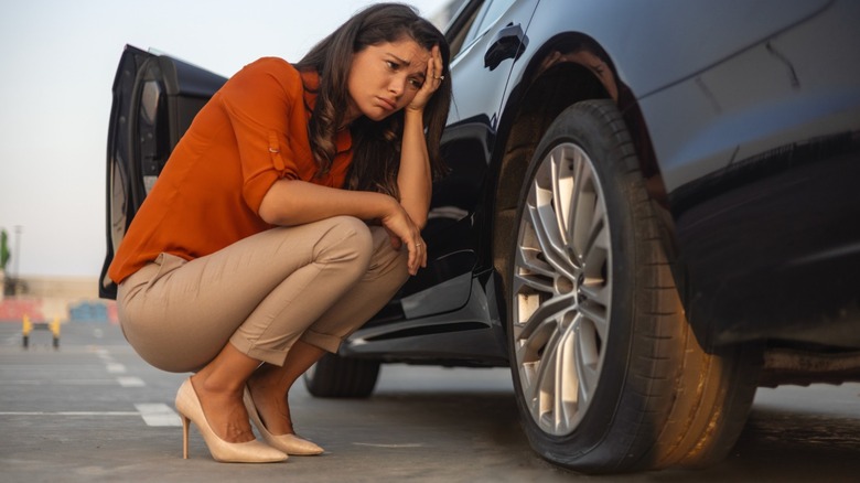 Woman upset over discovering she has a flat tire