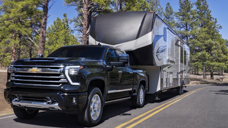 2026 black Chevy Heavy Duty pickup towing RV trailer